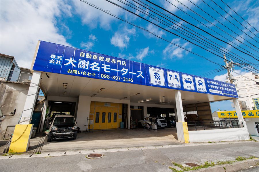 青空の下の大謝名モータース店舗外観